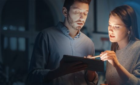 Two people looking at the screen of a tablet