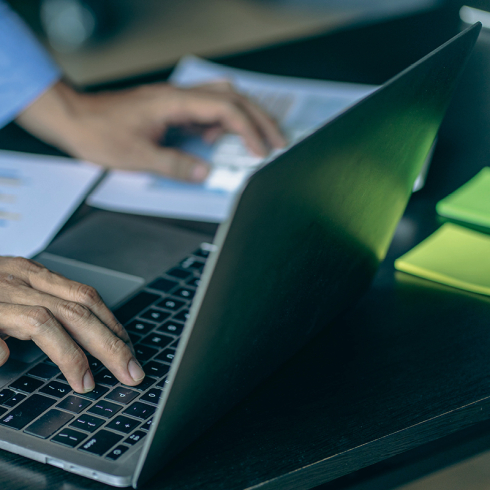 Person working on a laptop at their desk