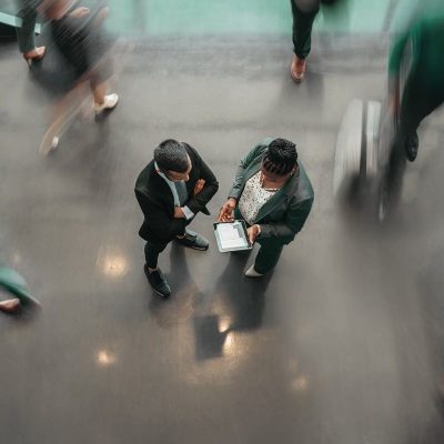 Two people talking in a busy office setting
