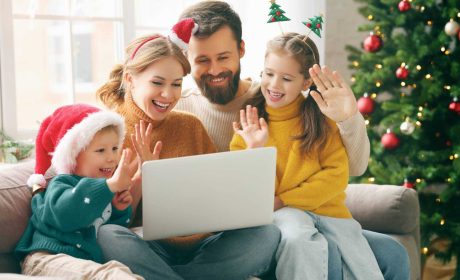 Family smiling while waving at a tablet at Christmas