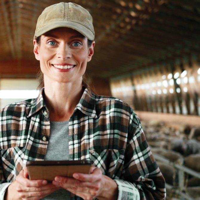 Farmer smiling while holding a tablet
