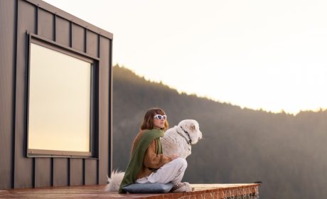 A woman and her dog sitting on the deck at their off-grid home