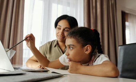 Mother & Daughter sitting at the table on a laptop