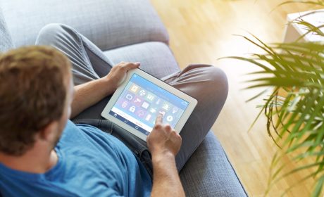 A man sitting on the sofa using a tablet