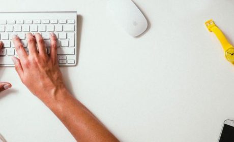 A person sitting at a desk typing on a keyboard