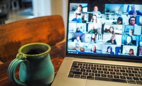 Picture of a laptop whilst on a video conference call with a mug of coffee to the side