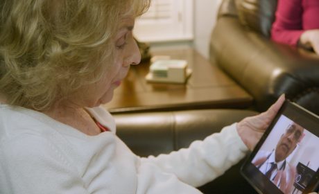A woman communicating with her doctor over a tablet.