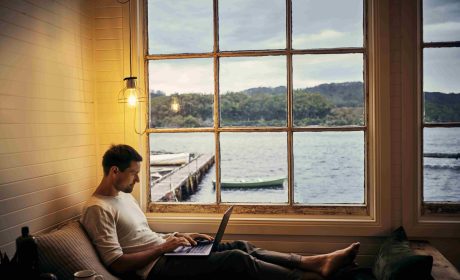 Man at Lakeside Cottage on Laptop with Fast Internet from Xplore