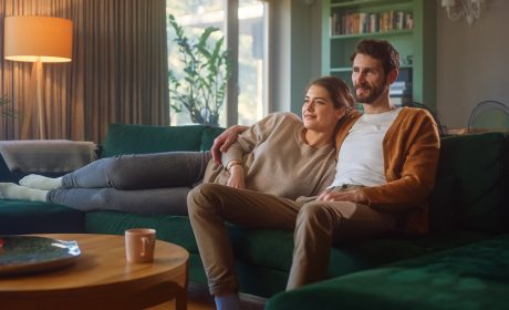 A couple enjoying streaming TV while sitting on couch using high-speed Internet in Canada