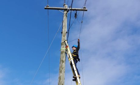 Picture of man on utility line installing Fibre Optics Cables in PEI