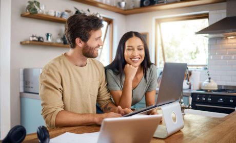 Husband and wife in kitchen using laptop with Fast Rural Internet in Canada