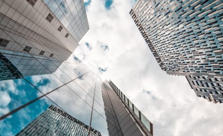 A photo looking up at the sky between three skyscrapers