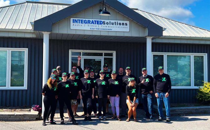 A picture of the Integrated Solutions Team wearing Xplore shirts and hats in front of their office.