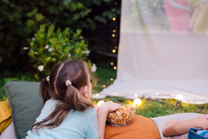 A child outside watching a movie