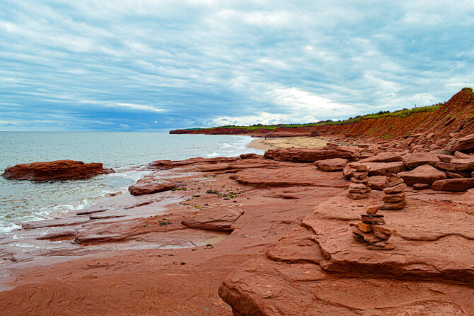 A photo of a sandy red beach in PEI
