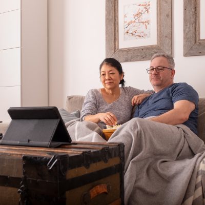 Couple sitting on the sofa looking at their tablet