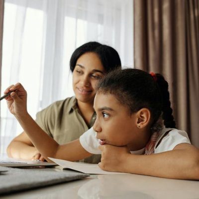 Mother & Daughter sitting at the table on a laptop