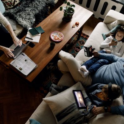 Family sitting down in the living room using their devices