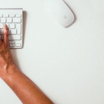 A person sitting at a desk typing on a keyboard