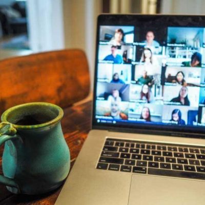 Picture of a laptop whilst on a video conference call with a mug of coffee to the side