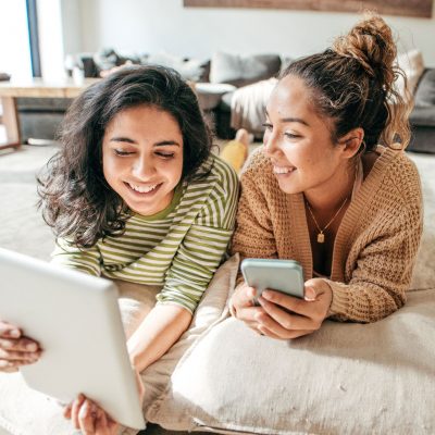 A photo of two people happily using their smartphones