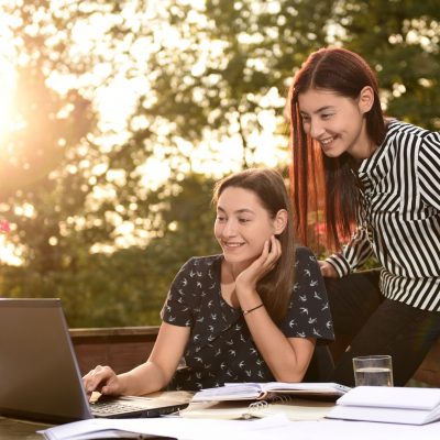 Une image de deux clients de Xplore se servant d'un ordinateur portable sur une terrasse extérieure.