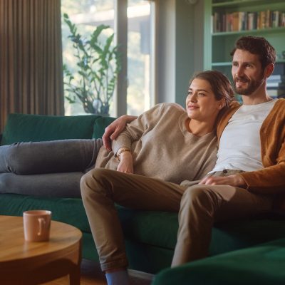 A couple enjoying streaming TV while sitting on couch using high-speed Internet in Canada