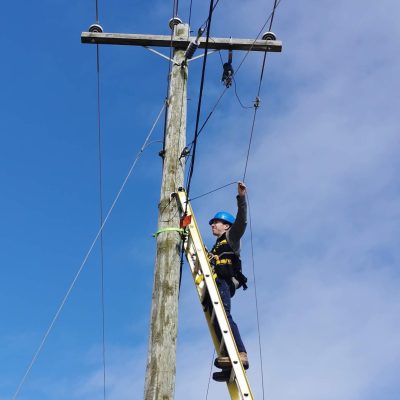 Picture of man on utility line installing Fibre Optics Cables in PEI