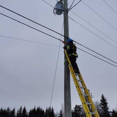 Fibre internet in PEI - Man installing it on pole