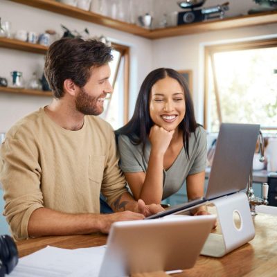 Husband and wife in kitchen using laptop with Fast Rural Internet in Canada