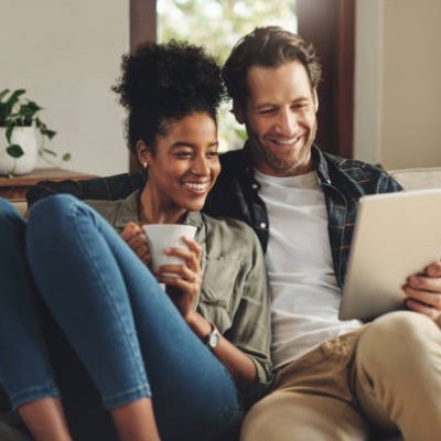 Young couple sitting on the sofa using a tablet