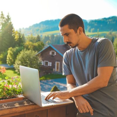 Man using laptop outside in rural Canada with Fast Internet