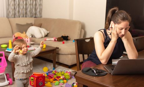 Tired mother trying to work on a laptop at home during her kid crying. Childcare and working mom concept. Women powerful. Toddler tantrum.