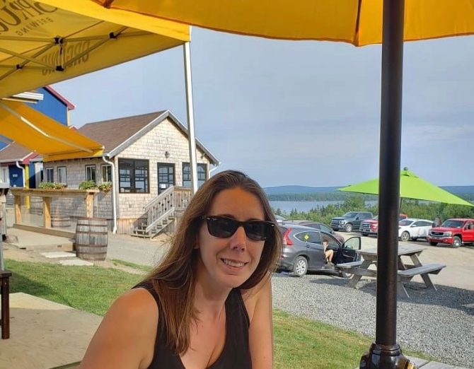 Tara sitting under a yellow umbrella