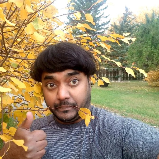 Person smiling by Fall leaves