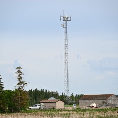 A photo of a cell tower located on a rural property.