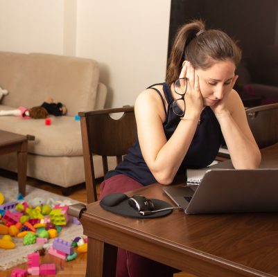 Tired mother trying to work on a laptop at home during her kid crying. Childcare and working mom concept. Women powerful. Toddler tantrum.