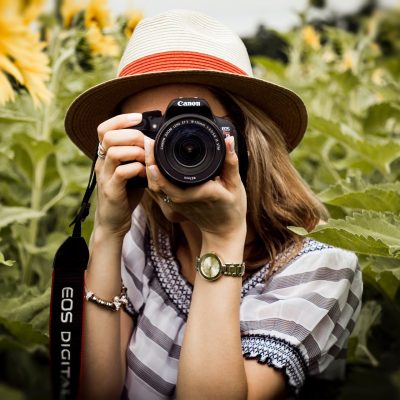 An image of a woman with a camera raised to her eye.